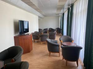 a waiting room with chairs and a flat screen tv at Aranypart Hostel in Siófok