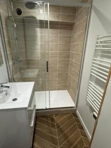 a shower with a glass door in a bathroom at Au cœur de Port in Port-en-Bessin-Huppain +8 photos