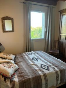 a bedroom with a large bed with a window at Chez Benoit, séjour Zen, chambre d'amis in Mazerolles