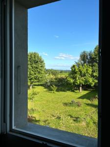 a window with a view of a field of grass at Chez Benoit, séjour Zen, chambre d'amis in Mazerolles
