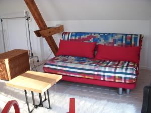 a couch with red pillows and a table in a room at Ferienwohnung Wolfshagen in Wolfshagen
