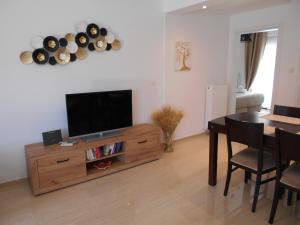 a living room with a television and a dining room table at Pepi Cozy in Alexandroupoli