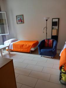 een slaapkamer met een bed en een blauwe stoel bij Apartamento vicino Policlinico San Donato in San Donato Milanese