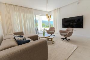 een woonkamer met een bank, twee stoelen en een tv bij Villa Bellevue in Mostar