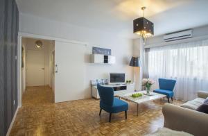 ein Wohnzimmer mit einem Sofa, einem Tisch und Stühlen in der Unterkunft Omerou Apartment in Nikosia