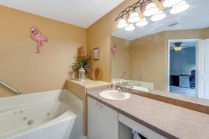a bathroom with a sink and a tub and a pink flamingo wall at North Port Home with Charming Lanai about 7 Mi to Beach in North Port +24 photos