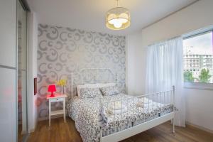 ein Schlafzimmer mit einem weißen Bett und einem Fenster in der Unterkunft Omerou Apartment in Nikosia