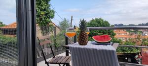 a table with a glass of wine and a pineapple on a balcony at La Cueva del Sacristán in Luanco