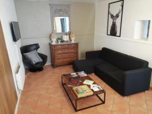 a living room with a black couch and a table at Le Perchoir in Mérindol