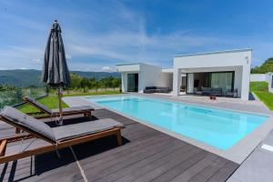 a villa with a swimming pool and an umbrella at Villa Bellevue in Mostar