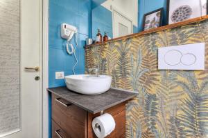 a bathroom with a sink and a blue wall at Maison Saporiti in Vigevano