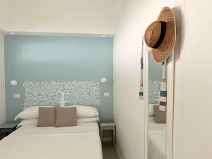 a bedroom with a bed and a hat on the wall at Starhost - CASA BONNIE, large furnished balcony on the Cathedral and a stone's throw from seafront, beach and ferry's pier in Minori