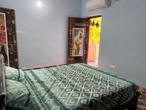 a bedroom with a bed with a green comforter at Dwaraka Home Stay in Tirupati
