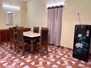 a dining room with a table and a refrigerator at Dwaraka Home Stay in Tirupati