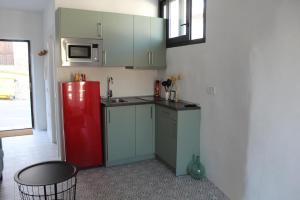 a small kitchen with a red refrigerator in a room at Honey Studio in Colmenar