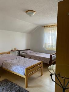 a bedroom with two beds and a window at Panorama Pokoj Apartments in Bihać