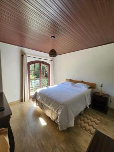 une chambre avec un grand lit avec un plafond en bois dans l'établissement Ninho dos Pássaros Chalés, à Monte Verde 57 autres photos