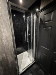 a glass shower in a bathroom next to a door at Cozy double near Train Station in Birmingham