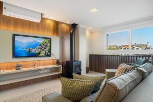a living room with a couch and a flat screen tv at Catedral de Pedra Plaza 2 dorm by Achei in Canela