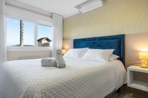 a bedroom with a white bed with towels on it at Catedral de Pedra Plaza 2 dorm by Achei in Canela