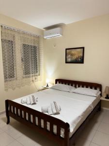 een slaapkamer met een groot bed met witte lakens en kussens bij Brand New Apartament Durres in Durrës
