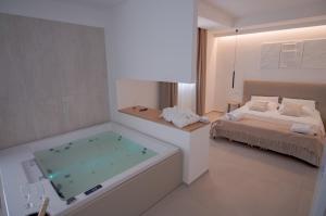 a bathroom with a tub and a bedroom with a bed at B&B Le Muse in Mondello