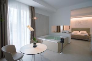 a bathroom with a table and a tub and a bed at B&B Le Muse in Mondello