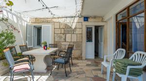 a patio with chairs and a table and a table and chairs at Oleander House in Lumbarda