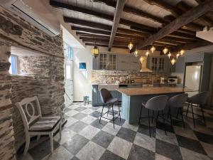 a kitchen with a counter and chairs in a room at Plomari Nomad House in Plomari