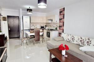 a living room and kitchen with a couch and a table at FLH - Garden Grill Escape in Sibiu +16 photos