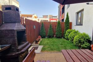 a backyard with a fireplace and a wooden fence at FLH - Garden Grill Escape in Sibiu