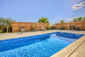 a swimming pool in a backyard with chairs around it at Villa Harmony - Apartments in Banjole