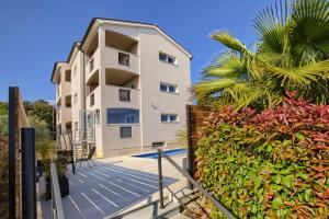 an apartment building with a staircase and a palm tree at Villa Harmony - Apartments in Banjole