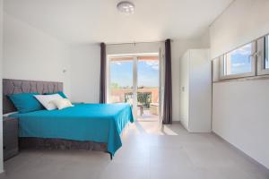 a bedroom with a blue bed and a large window at Villa Harmony - Apartments in Banjole +26 photos