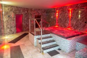 a bathroom with a tub with red lighting and stairs at Badgers Hollow Lodge in Windermere