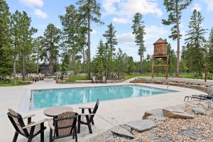 a pool with a table and chairs and a water tower at The Juniper - Hot tub in Lead
