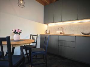 a kitchen with a wooden table and a vase with flowers at Vėjų kraštas in Svencelė
