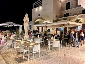 a restaurant with tables and umbrellas with people sitting at them at Evo Suite & Spa in Vieste