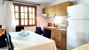 a kitchen with a table and a white refrigerator at Katy's Home in Próti