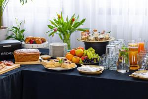 ein Tisch voller Teller mit Speisen und Obst in der Unterkunft Hotel Kopczyński in Dobre Miasto