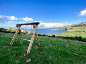 a wooden frame in a field with a lake at Monteverde in Tota