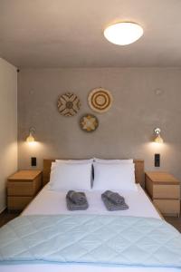 Un dormitorio con una cama blanca con dos toallas encima. en ILIOS Luxury Apartment, en Nea Iraklitsa