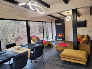a living room with a table and chairs and a fireplace at Cabanele din Valea Ursului in Bîrsana