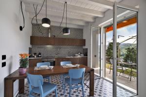 a kitchen with a wooden table and blue chairs at Appartamenti Caffè Maya in Maslianico