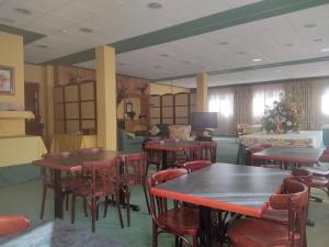 a dining room with tables and chairs and a tv at Hotel Suite Mioño Castro Urdiales in Castro-Urdiales