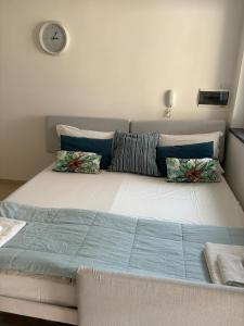 Cama grande en habitación con reloj en la pared en cerasella house, en Castellammare di Stabia 19 fotos más