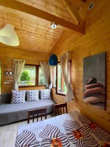 een slaapkamer in een blokhut met een bed en een bank bij Leśny Domek in Kopalino