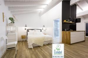Un dormitorio blanco con una cama y una cocina. en Markulluko Borda Rural Suites, en Elizondo