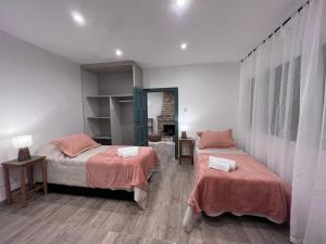 a bedroom with two beds with orange sheets at Casa de Campo Ana María in Tupungato