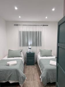 a bedroom with two twin beds and a window at Casa de Campo Ana María in Tupungato